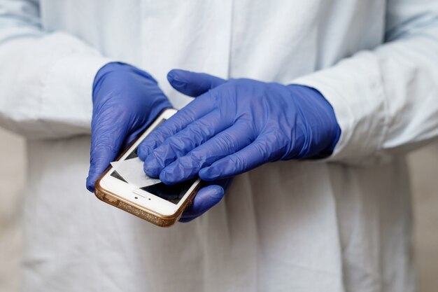 Doctor treats phone with an antiseptic, antiviral treatment