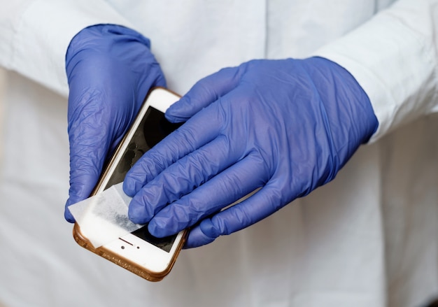 Doctor treats phone with an antiseptic, antiviral treatment