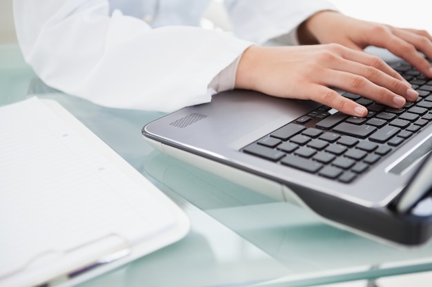 doctor typing on her laptop