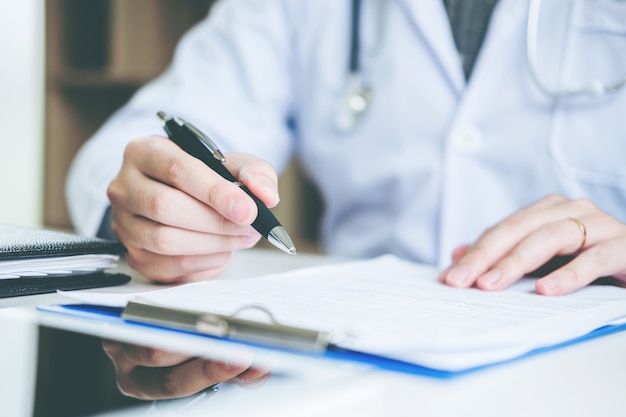 Doctor typing information working in Hospital office focus on Stethoscope