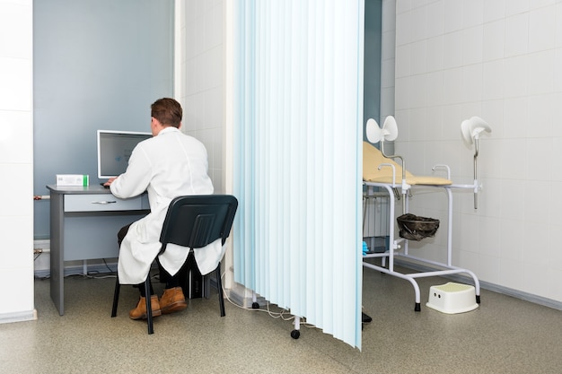 Photo doctor typing and using his computer in the office