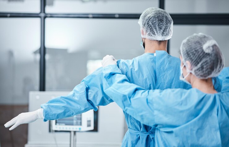 Photo doctor uniform and surgeon prepare for surgery operation or medical healthcare nurse helping worker with safety clothing in emergency operating room hospital and wellness support theater or risk