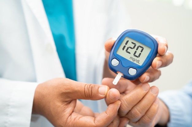 doctor use digital glucose monitor measure and test stripe for check diabetes from finger blood sugar level