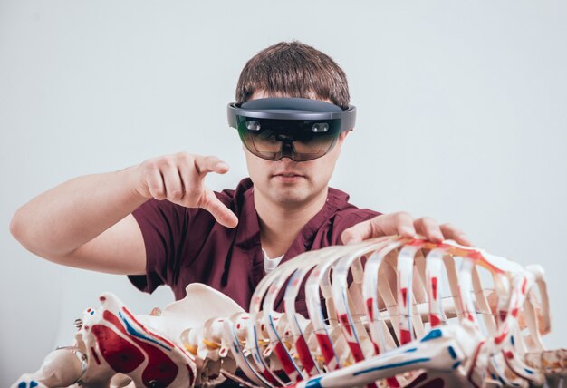 Doctor uses augmented reality goggles to exam human skeleton