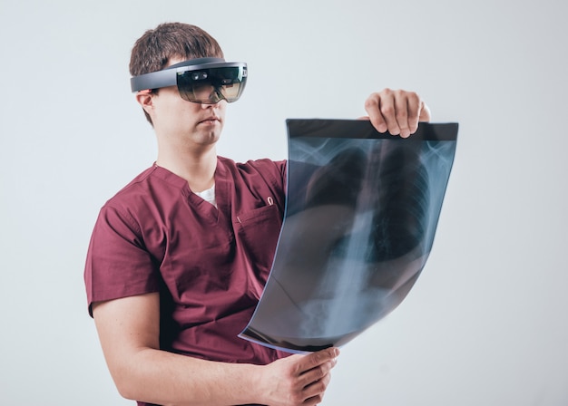 의사는 증강 현실 고글을 사용하여 인간 골격으로 엑스레이 필름 검사