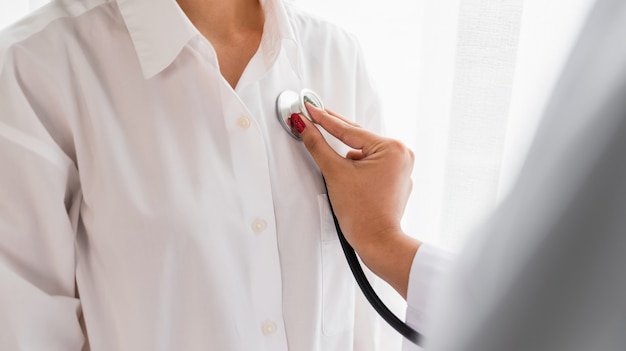 The doctor uses a stethoscope to check the patient's heart rate.