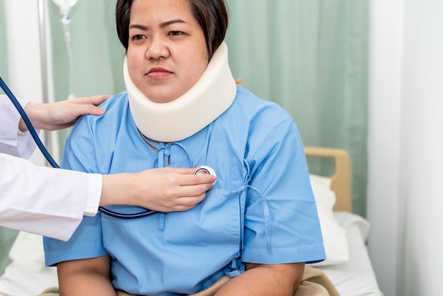 청진기를 사용하는 의사 목 부목을 착용하는 뚱뚱한 여성 환자의 심장 박동수 듣기