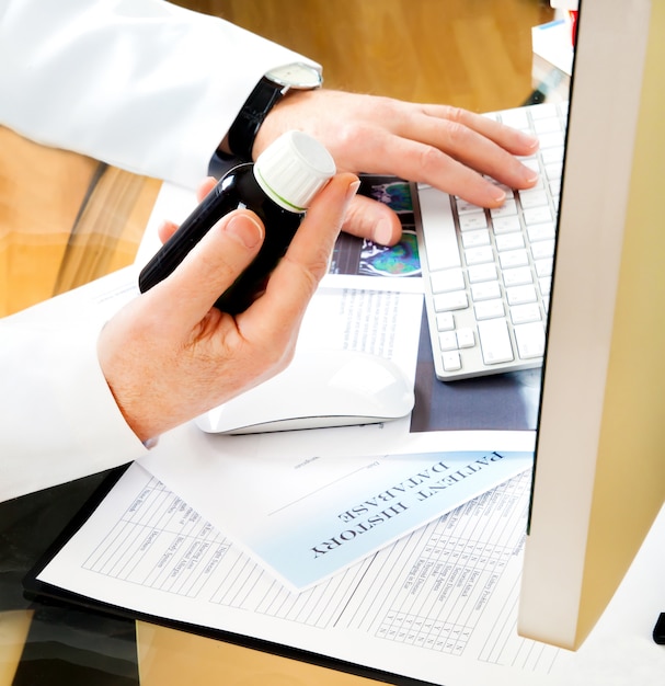 Photo doctor using a computer to prepare an online prescription