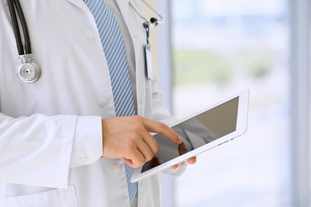 Doctor using a digital tablet closeup of hands Health care concept