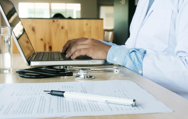 Photo doctor using laptop on table