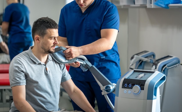 doctor using machine to treat the patients shoulders