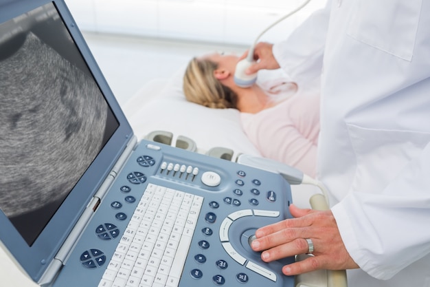 Foto medico con ecografia sul collo del paziente femminile