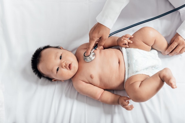 3개월 된 신생아의 호흡기와 심장 박동을 확인하는 청진기를 사용하는 의사
