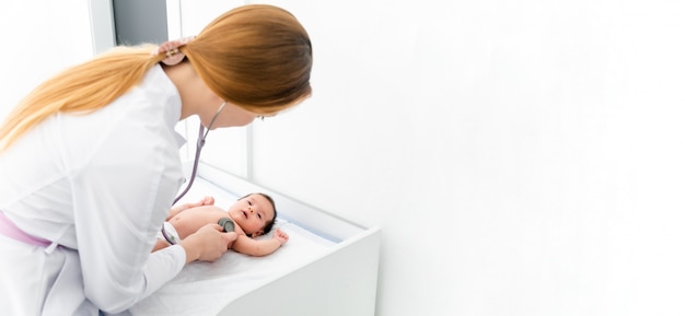 Doctor using a stethoscope to listen to kid's chest checking heartbeat