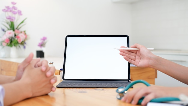 Doctor using tablet discussion something with patient.