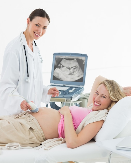 Doctor using ultrasound scanner on pregnant woman