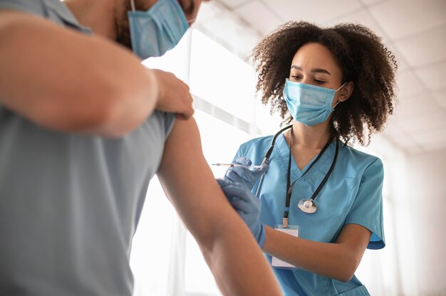 Foto medico che vaccina un paziente in una clinica