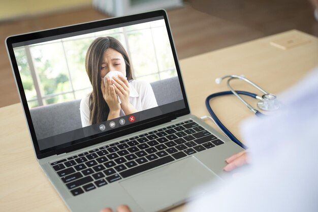 Photo the doctor video conference with a sick person with a cold and sneezing and ask for symptoms