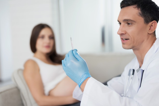 Doctor wants to give an injection to pregnant woman.