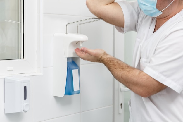 Doctor washing hands using disinfecting liquids in a surgical clinic