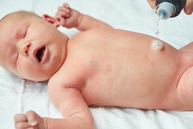 doctor washing a navel for a newborn baby