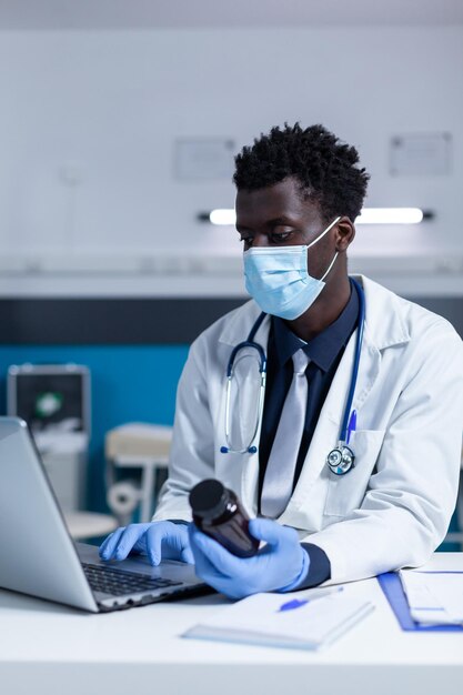 Doctor wearing mask holding medicine bottle