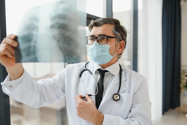 Photo doctor wearing mask and looking at chest xray