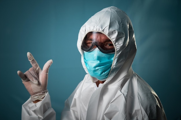 Doctor wearing personal protective equipment ppe suit for fighting covid19 corona virus on blue background Coronavirus outbreak or covid19 concept of covid19 quarantine