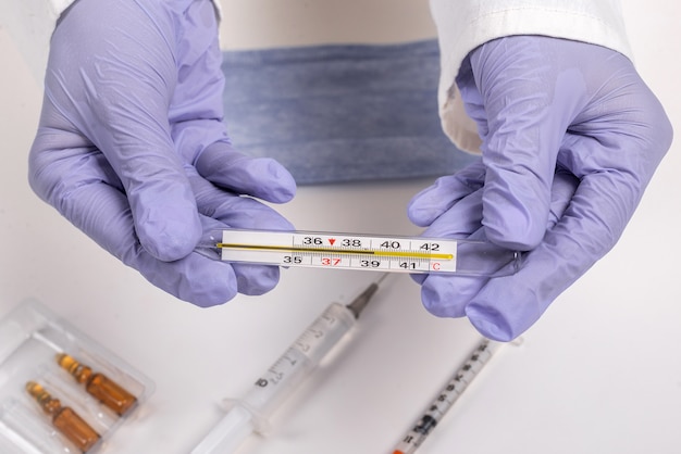 A doctor wearing surgical gloves and holding a vaccine