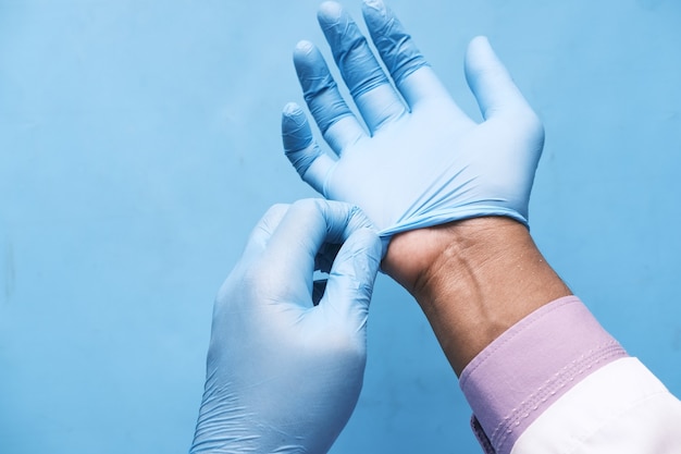 Doctor wears medical latex gloves close up