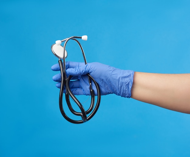 Doctor in a white medical coat holds a black stethoscope