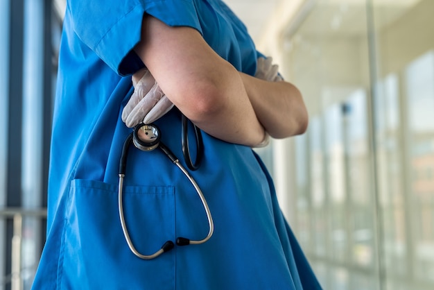 Il dottore in uniforme bianca tiene uno stetoscopio in clinica. concetto di assistenza sanitaria