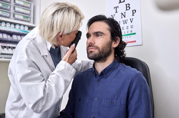 Фото Врач с мужчиной на проверке зрения или проверка зрения на зрение врачом-оптометристом или офтальмологом с медицинской помощью пациент или клиент с полезным старшим оптиком, чтобы увидеть или проверить глаукому