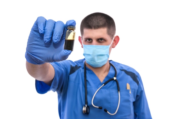 Doctor with ampoules. Man in blue medical uniform holding ampoules with vaccines isolated on white