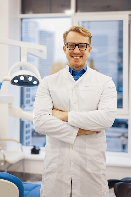 Doctor with crossed hands standing in dentistry medical room