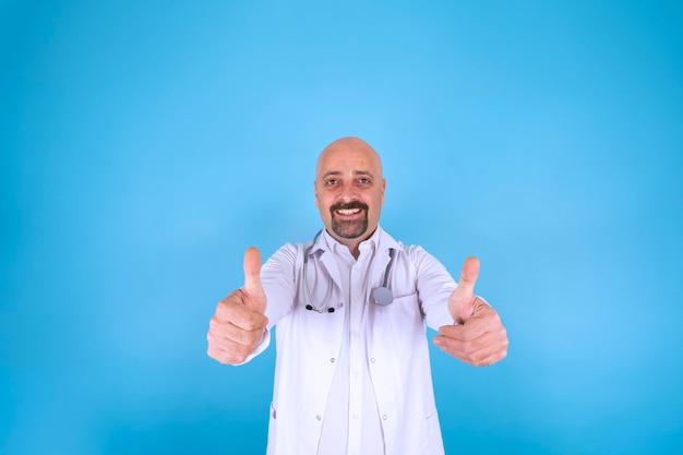 Photo a doctor with his thumbs up on a blue background