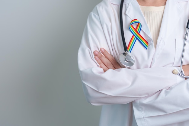 Doctor with LGBTQ Rainbow ribbon for Support Lesbian Gay Bisexual Transgender and Queer community and happy Pride month concept