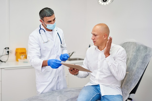 Doctor with man before aesthetic operation in medical clinic