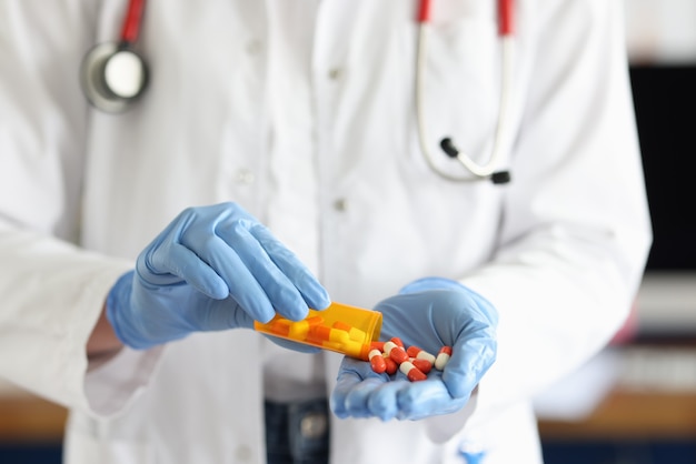 Doctor with medical gloves sprinkles pills on hand