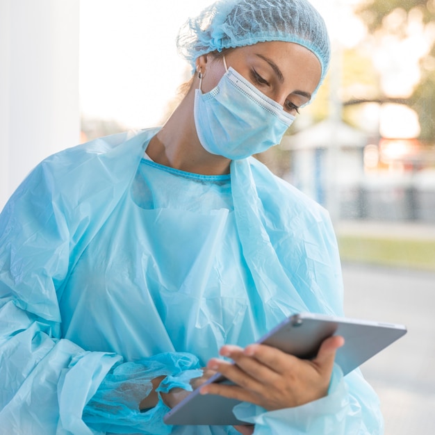 Doctor with medical mask looking on a clipboard