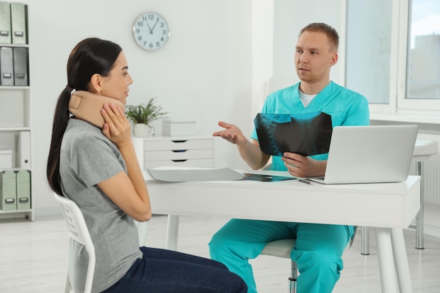 Doctor with neck MRI image consulting patient in clinic