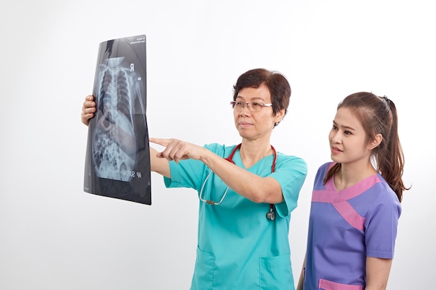 Доктор с медсестрой, исследующей рентгеновский снимок