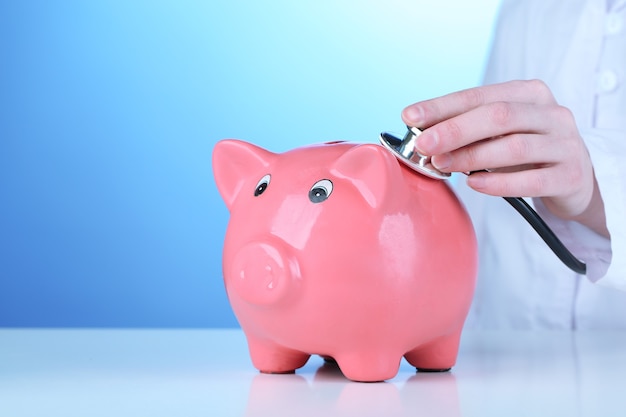 Doctor with pink piggy bank