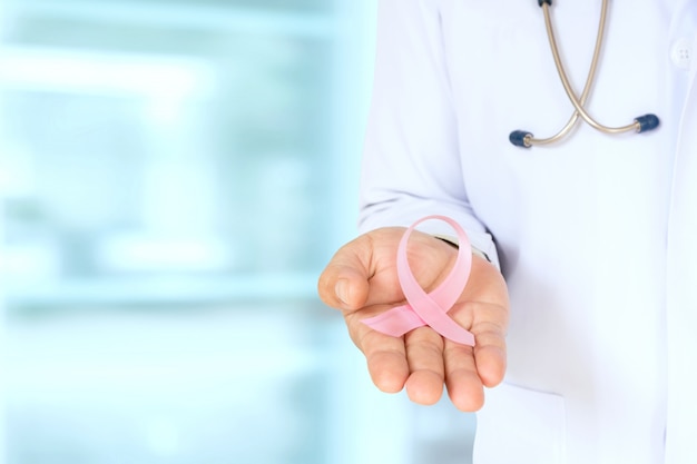 Фото Доктор с розовой лентой концепции рака молочной железы и стетоскоп.