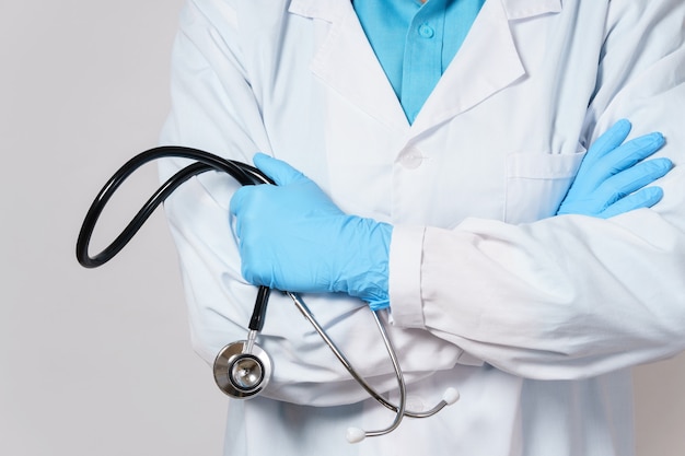 Doctor with a stethoscope on gray wall