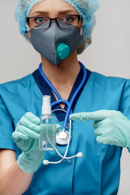 Doctor with stethoscope holding a bottle of sanitizer