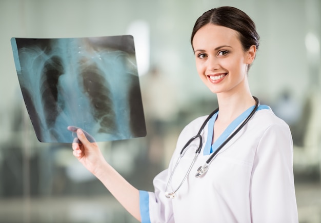 Doctor with stethoscope looking at X-ray at doctor's office.