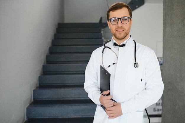 Doctor with stethoscope on stairs in hospital Space for text