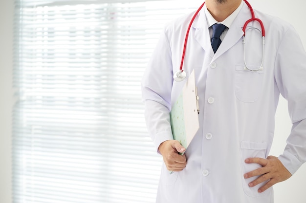 Doctor with a stethoscope and taking notes with bright background