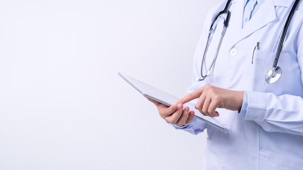 Doctor with a stethoscope in a white coat holding tablet